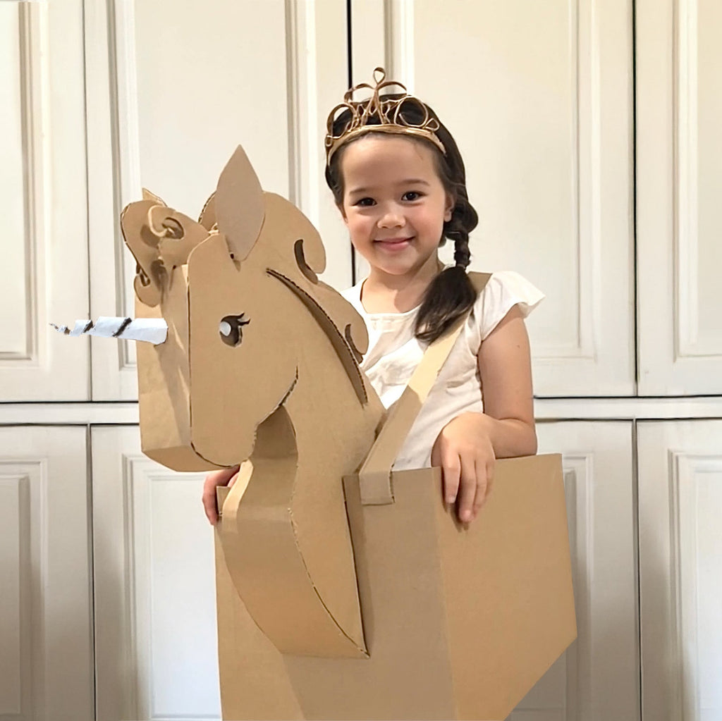 DIY Cardboard unicorn box costume worn with a white background
