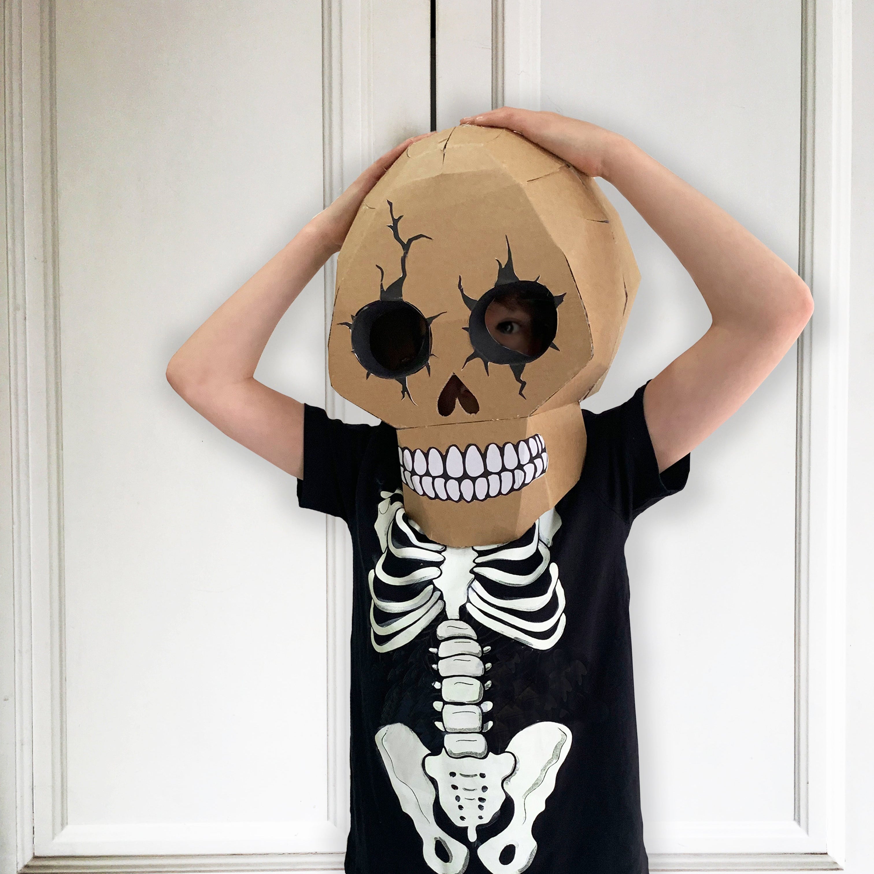 Person wearing a skeleton costume with a large cardboard skull head.